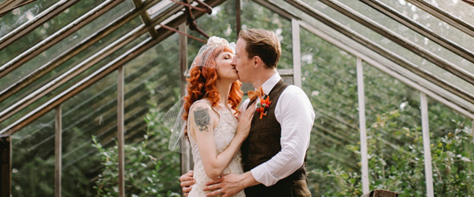 bride and groom kissing in the greenhouse